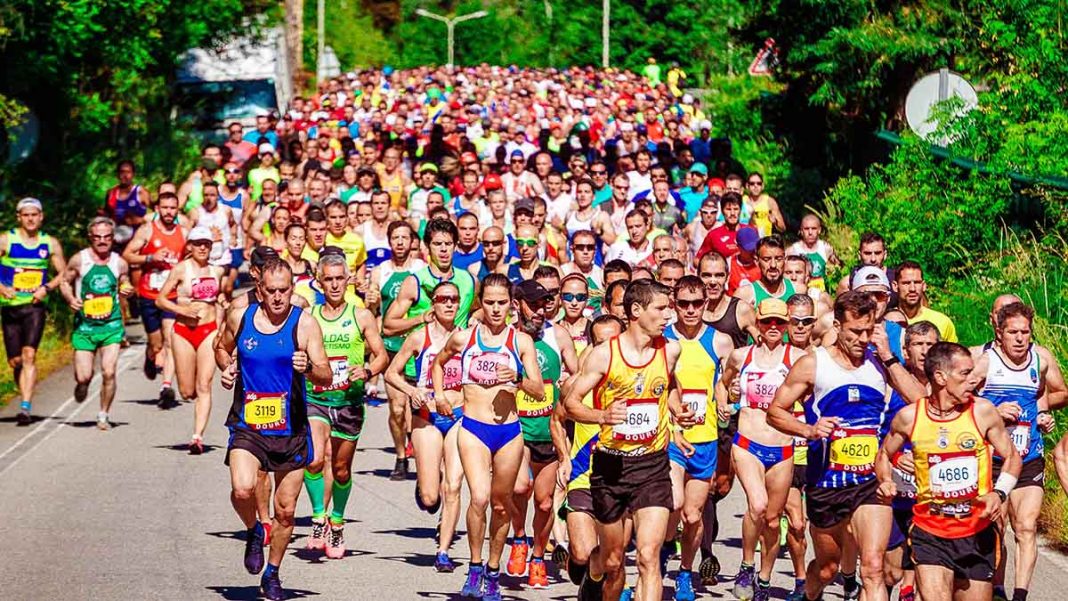 Large group of marathon runners racing together with strong energy and momentum.