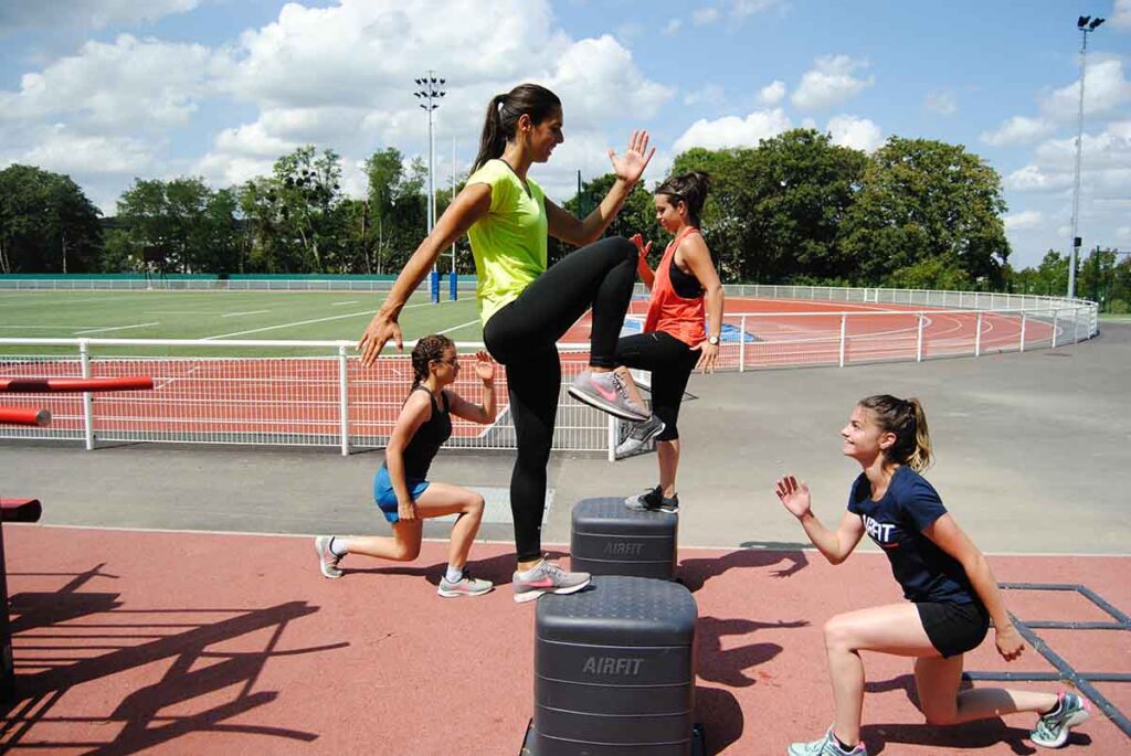 Runner doing plyo box step-ups for strength training outdoors.