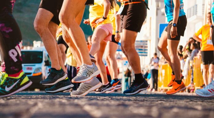 Why Your Easy Runs Are Holding Back Your Marathon Progress Close-up view of multiple runners beginning a race, showing only their legs and athletic running shoes in motion.