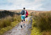 Iliotibial Band Syndrome in Runners: Prevention, Management, and Safe Return to Running Runner in athletic gear jogging on a city street with a highlighted area on the outer knee indicating IT Band Syndrome