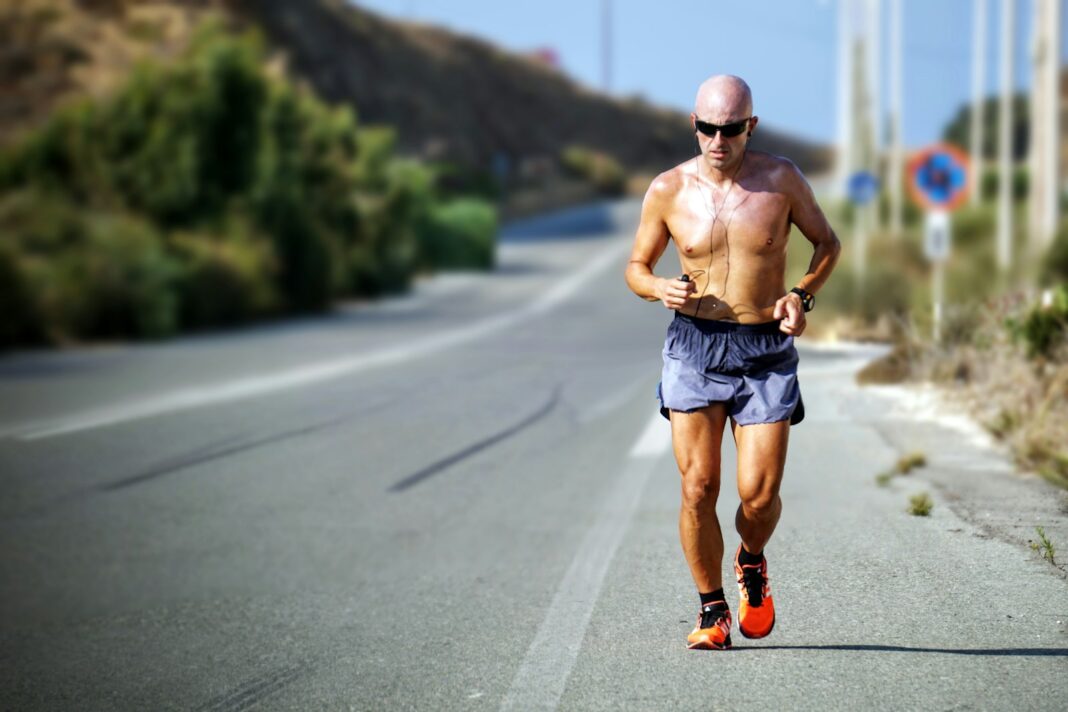 An experienced masters runner training solo on a coastal road