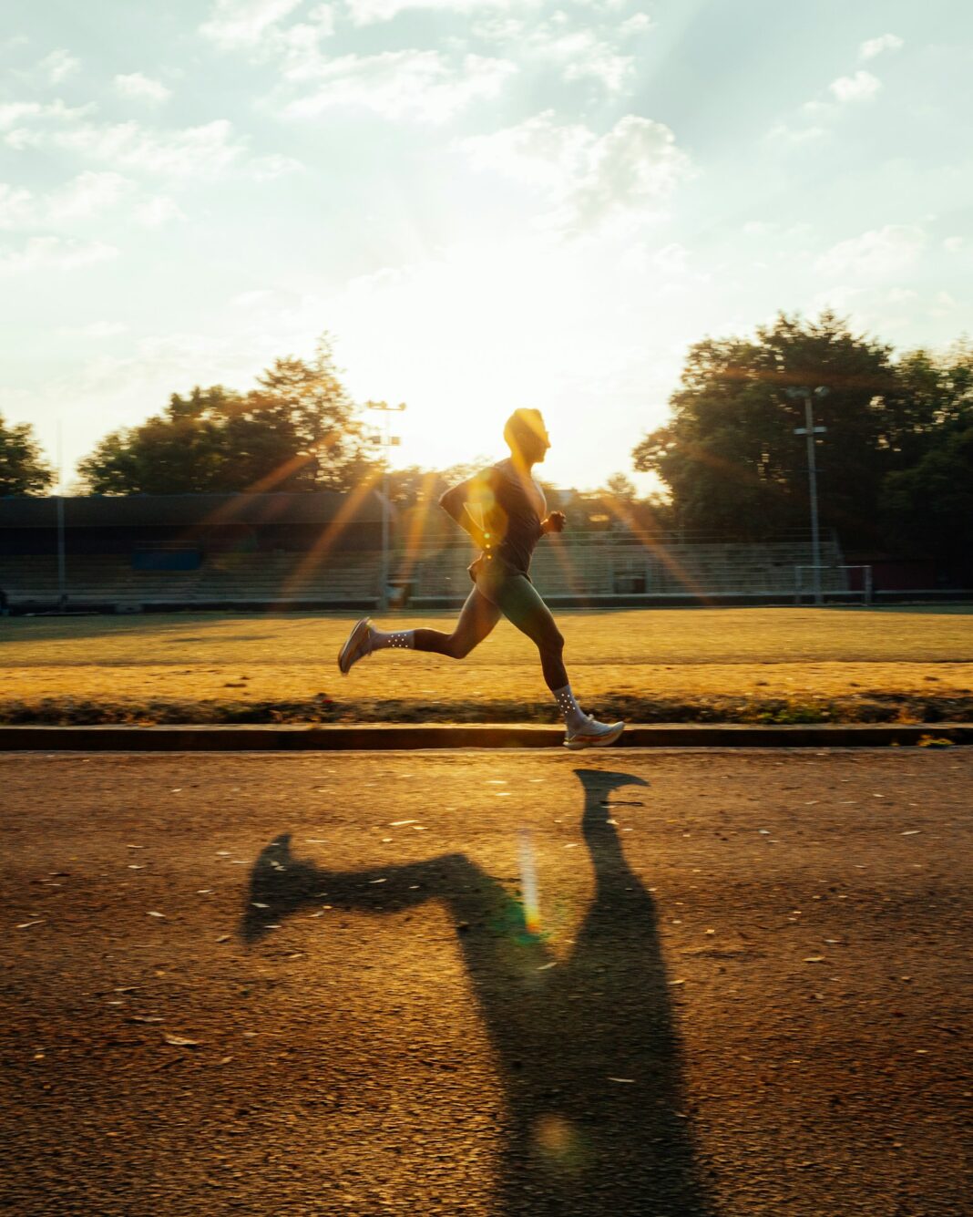 Runner sprinting on a track at golden hour